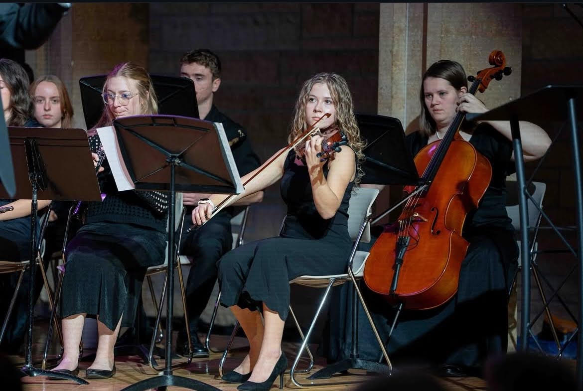 Angelina playing violin in an orchestral performance